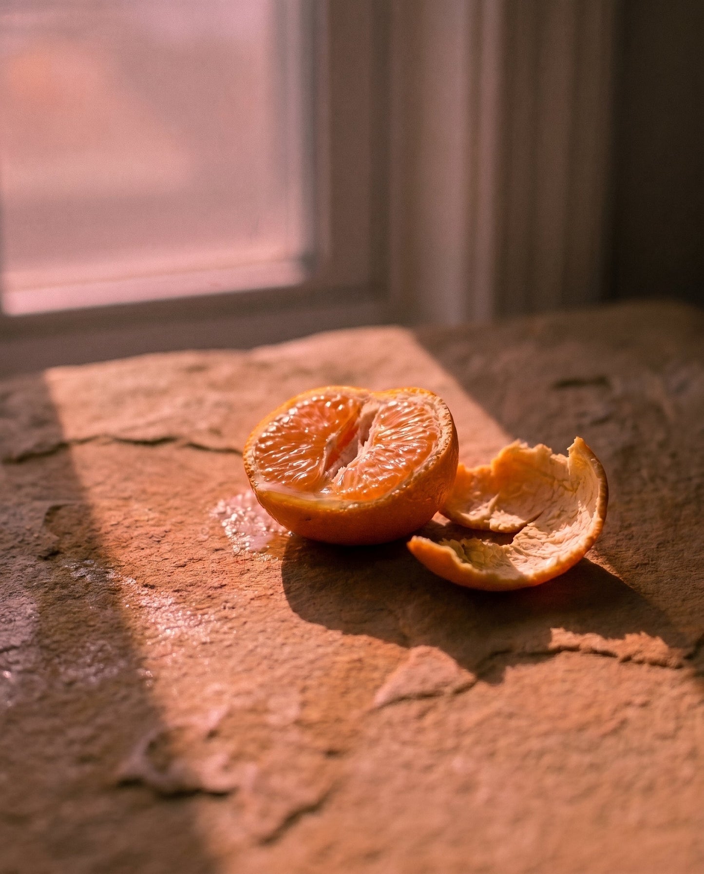 A peeled tangerine on a stone windowsill