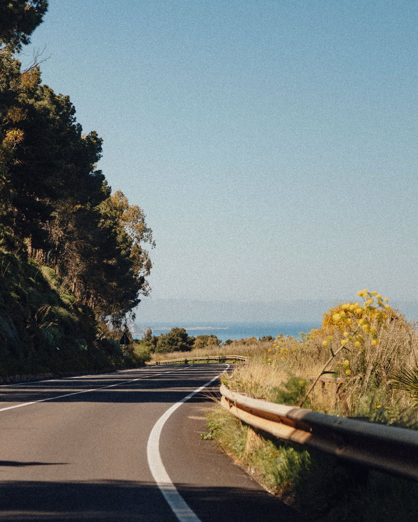 A coastal road curving toward the sea